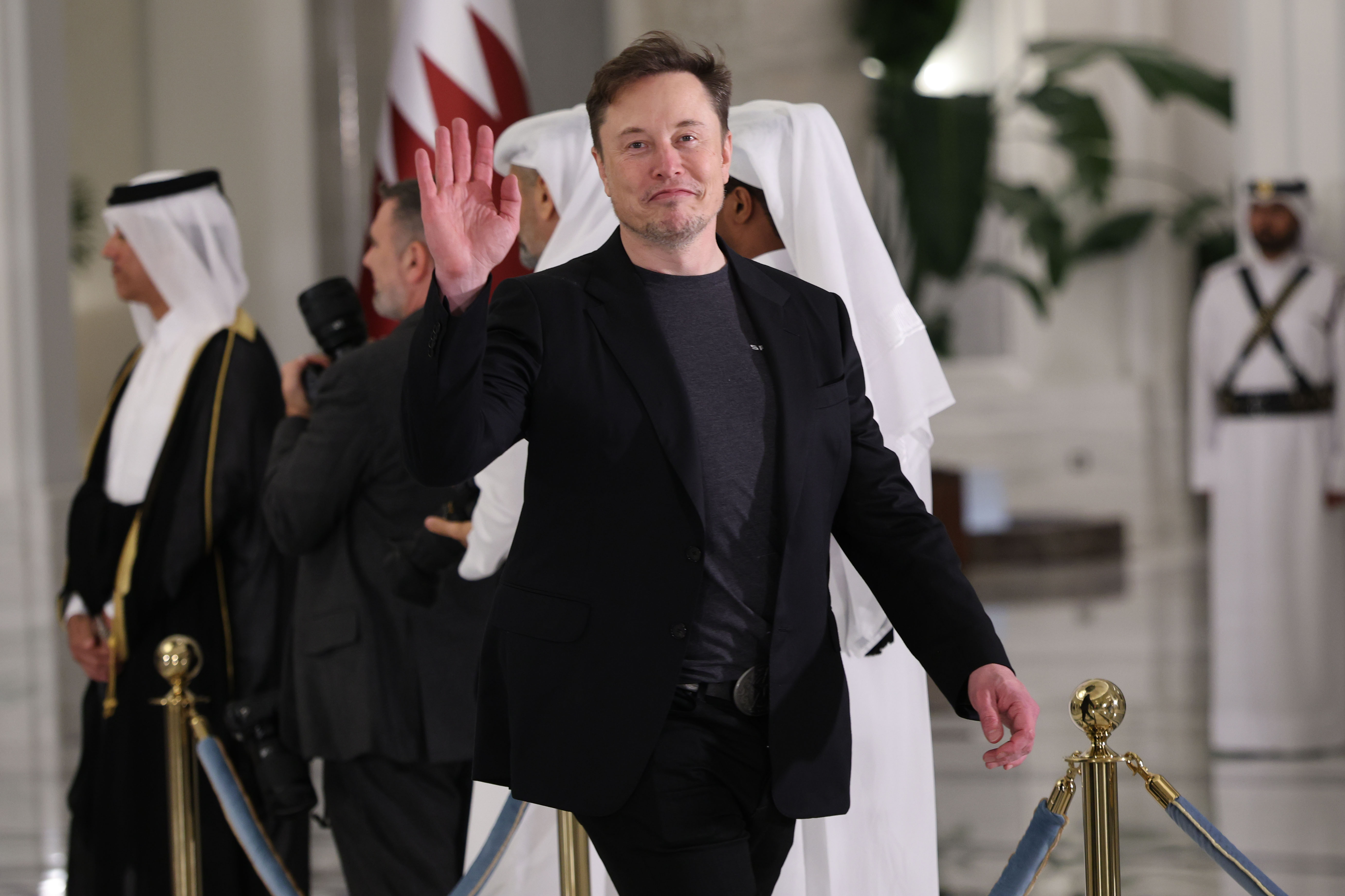 Elon Musk waving at a state dinner in Doha, Qatar.