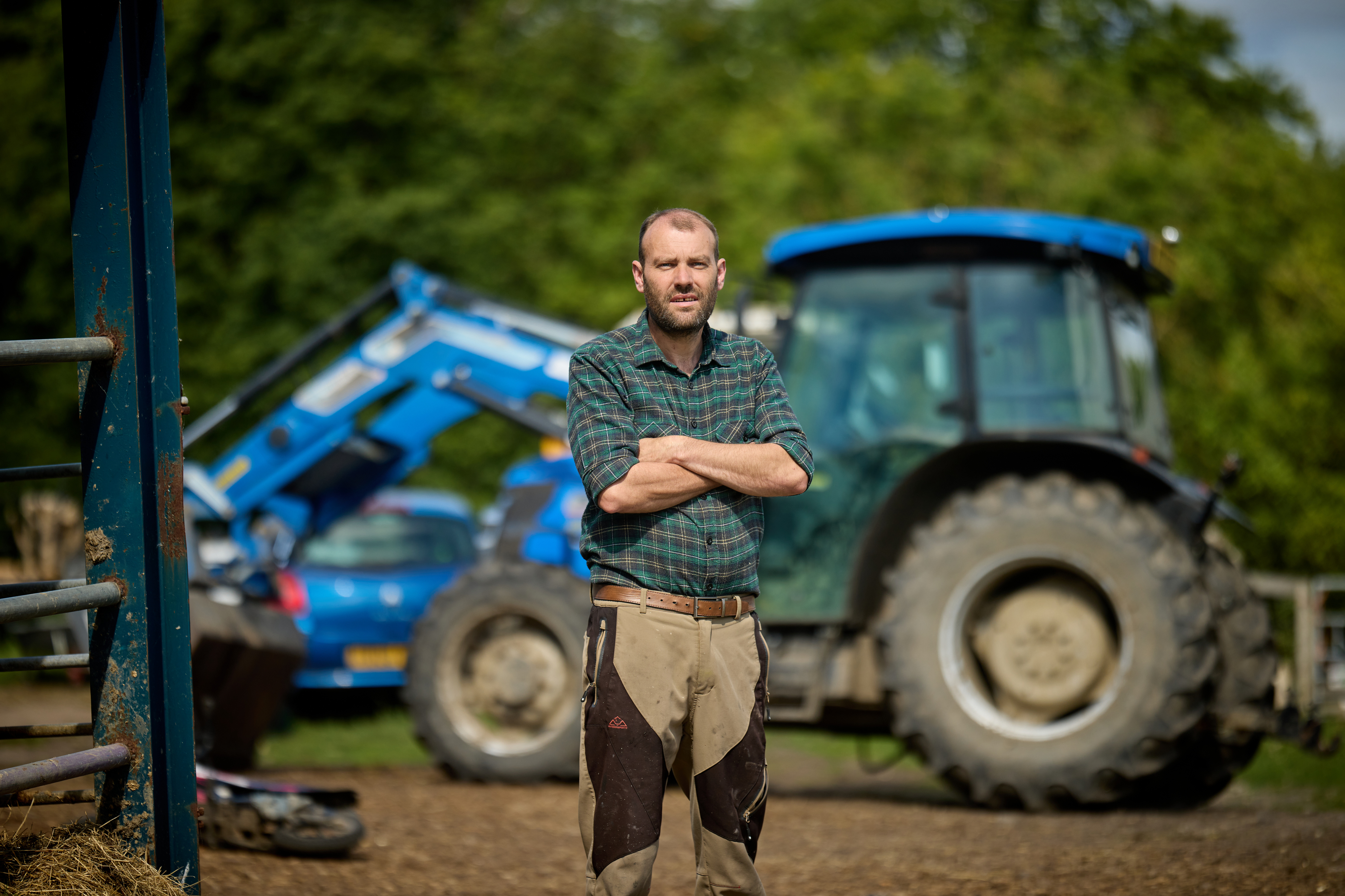 Farmer standing in front of a tractor.