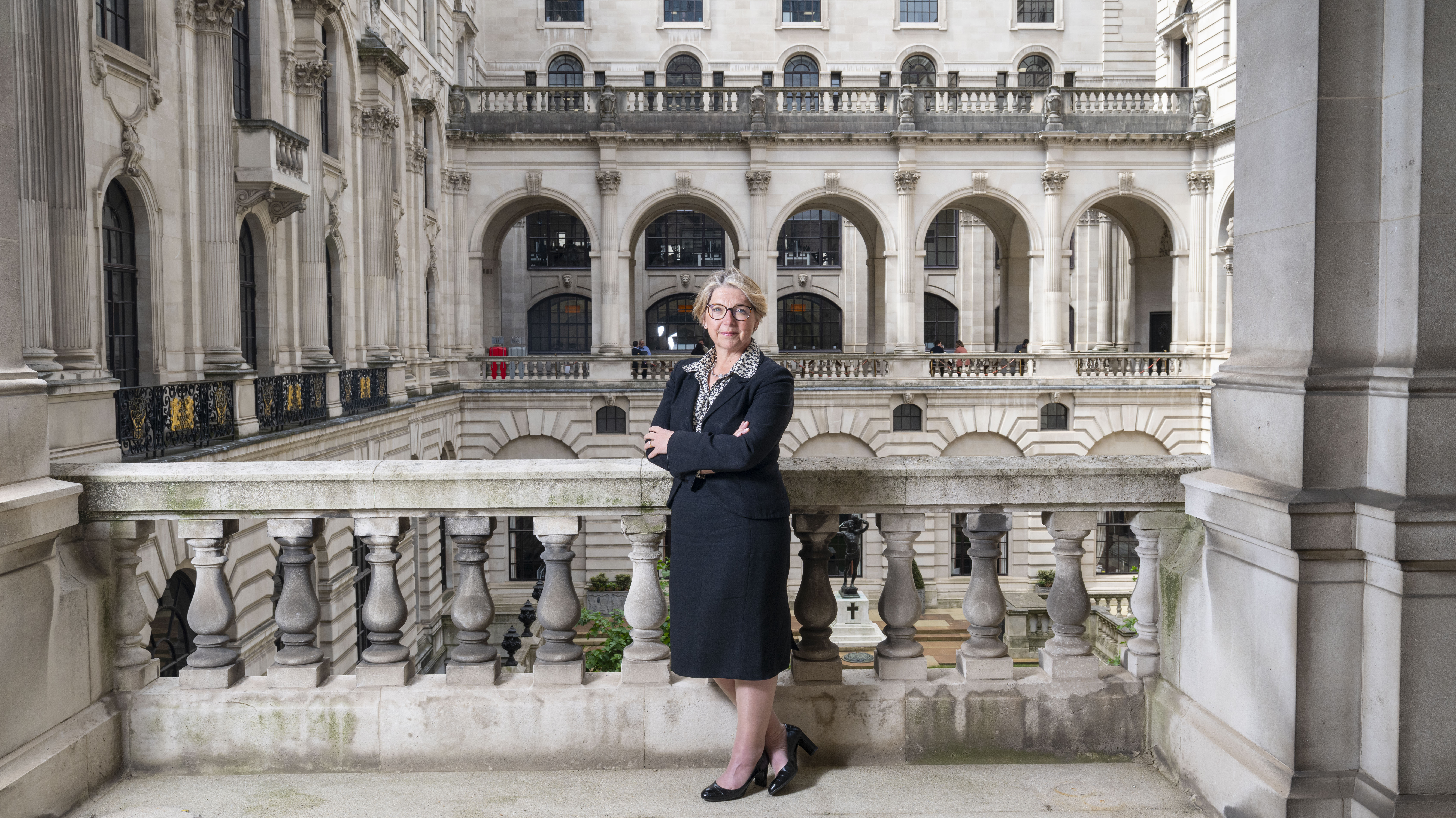 Portrait of Sarah Breeden, Deputy Governor of the Bank of England for Financial Stability, standing on a balcony.